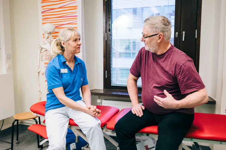 Man and a female physiotherapist talking.